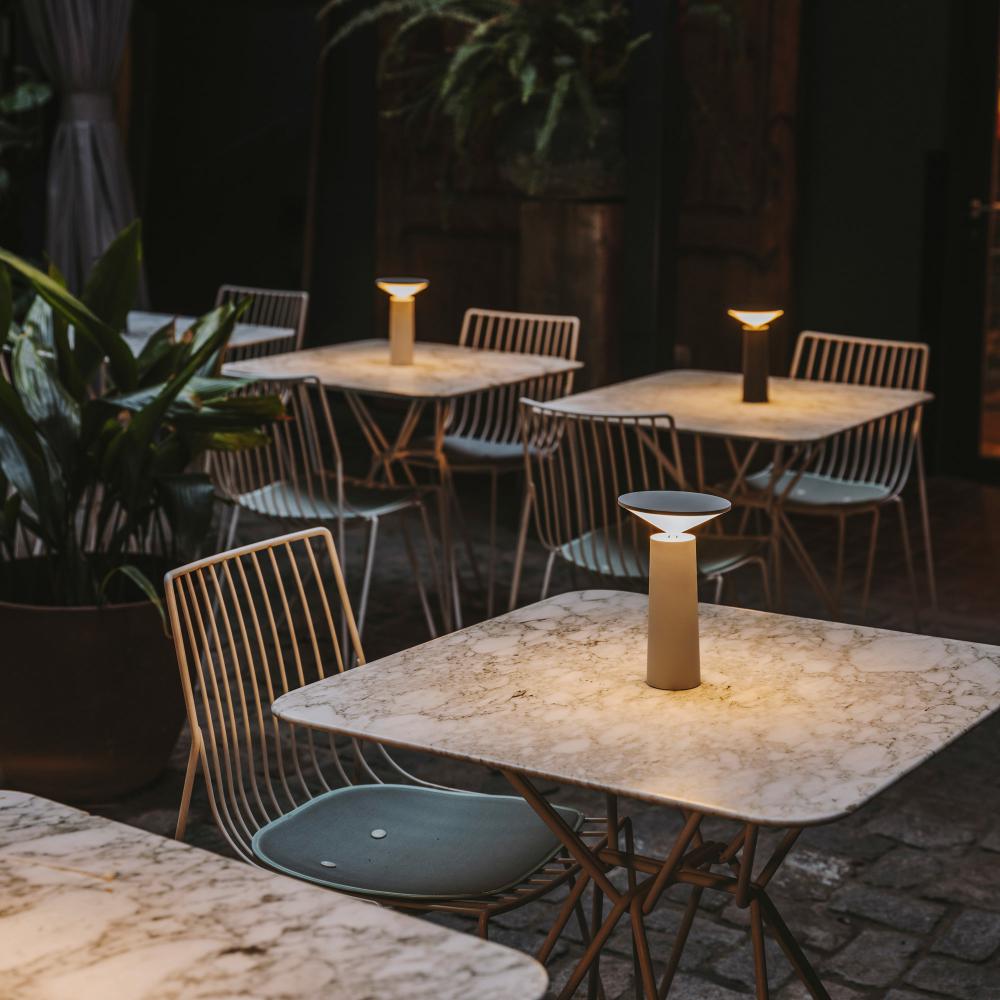 Moderne Tischlampe auf Marmortisch im Freien, stilvolle Beleuchtung, Gartenmöbel, Nachtambiente.