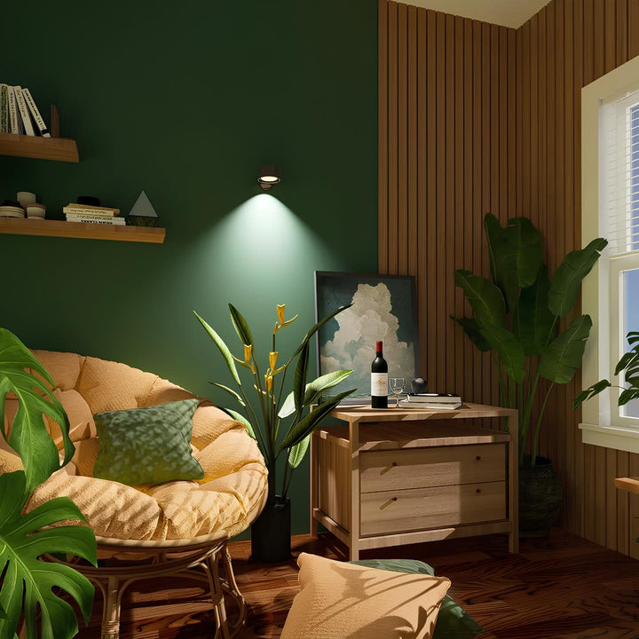 Gemütliches Wohnzimmer mit grünem Sessel, Holzmöbeln, Pflanzen und Wandkunst.