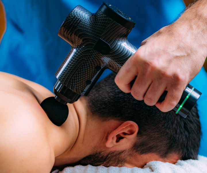 Mann erhält Massage mit schwarzer Massagepistole aus Carbon, Muskelentspannung, Therapie.