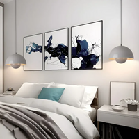 Modernes Schlafzimmer mit grauen Pendelleuchten, abstrakter Kunst und weißem Bett, stilvolle Einrichtung.
