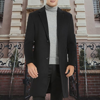 Mann im schwarzen Wollmantel vor historischer Fassade, eleganter Winterlook, Herrenmode.