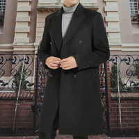 Mann in schwarzem Wollmantel vor historischer Architektur, stilvolle Wintermode.