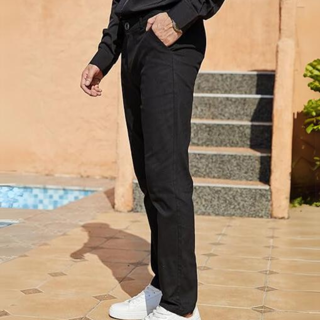 Mann in schwarzer Hose und weißen Sneakern auf Terrasse, modische Herrenbekleidung.