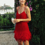 Frau in rotem Fransen-Kleid, Sommermode, elegantes Abendkleid, Outdoor-Event, stilvoll.