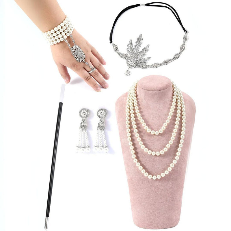 Perlenschmuck-Set mit Halskette, Armband, Ohrringen, Stirnband und Zauberstab auf rosa Ständer.