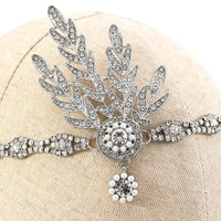 Silberne Strass-Haarspange mit Blattdesign und Perlenverzierung auf beigem Hintergrund.