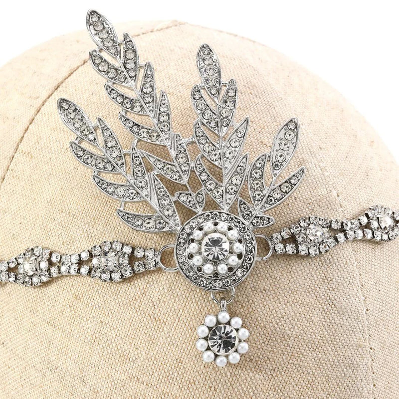 Silberne Strass-Haarspange mit Blattdesign und Perlenverzierung auf beigem Hintergrund.