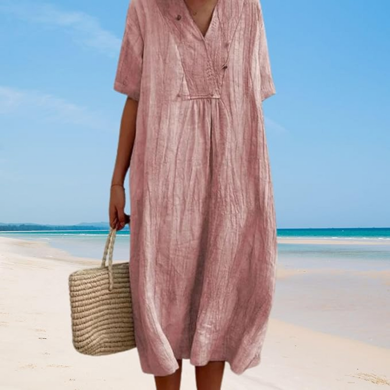 Frau im rosa Leinenkleid am Strand mit Strohtasche, Sommermode, Strandkleidung.