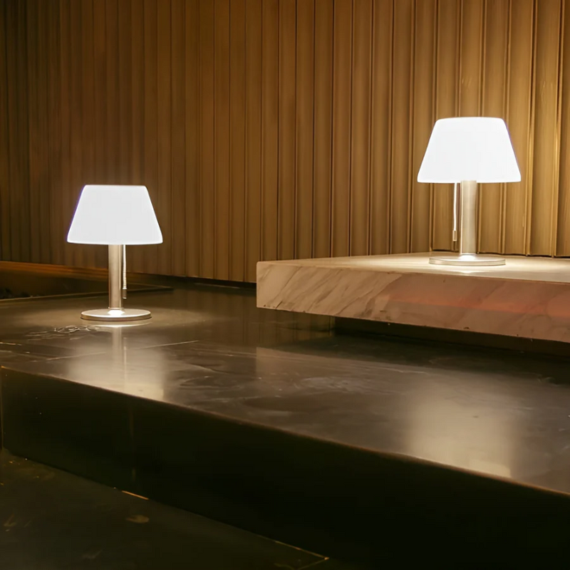 Zwei moderne Tischlampen mit weißem Schirm auf dunklem Marmortisch, stilvolle Beleuchtung.