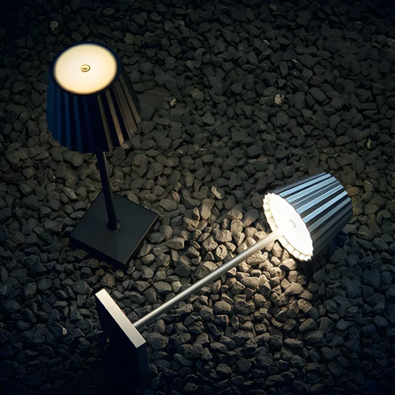 Schwarze LED-Tischlampen auf Kiesboden, modernes Design, energiesparend, Innenbeleuchtung.