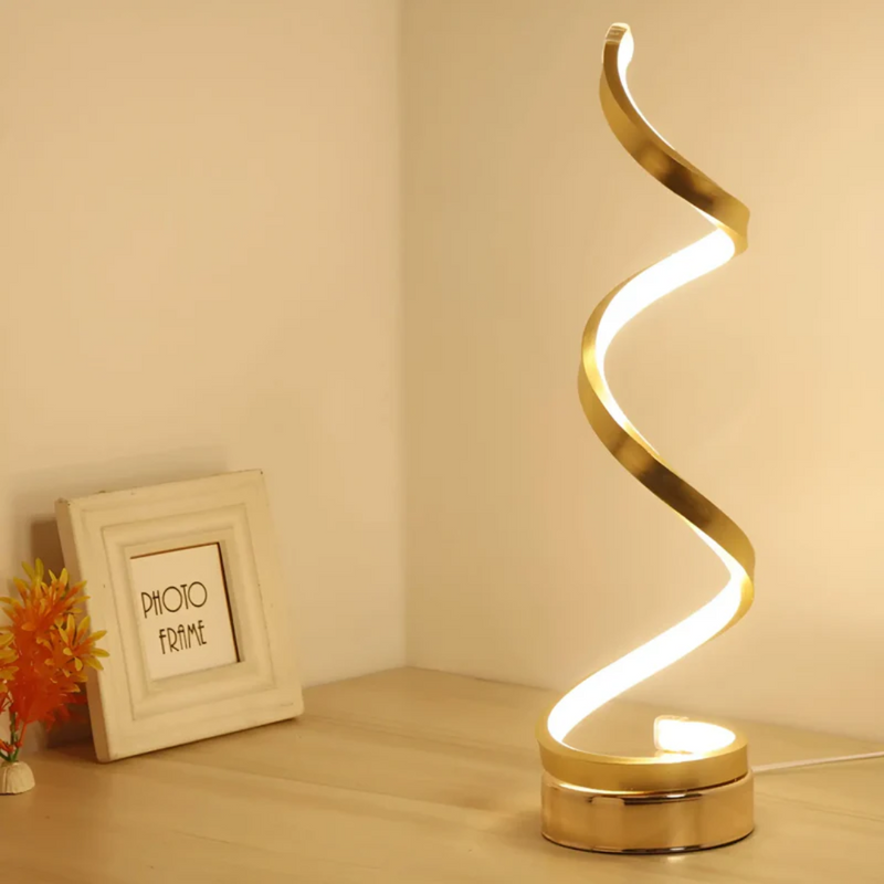 Goldene LED-Tischlampe, spiralförmig, modernes Design, warmweißes Licht, Holzuntergrund.