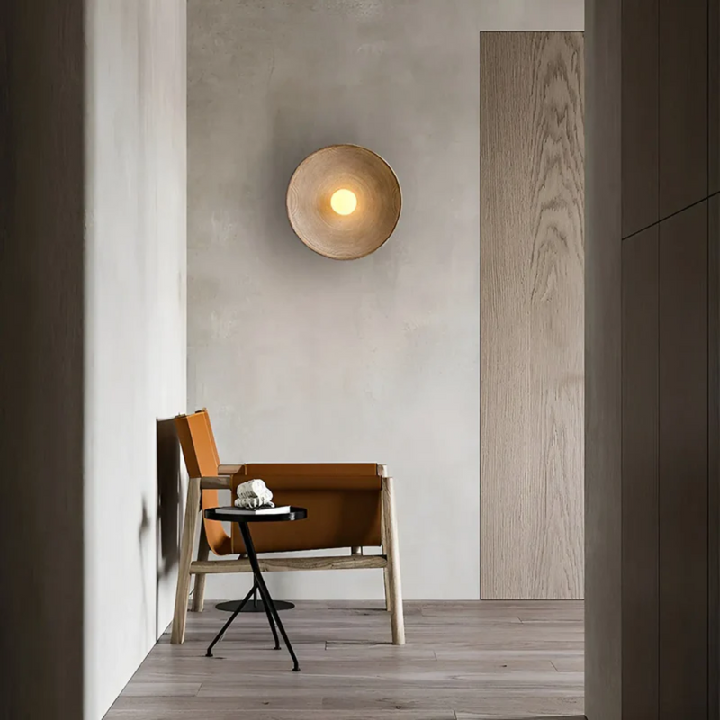 Moderner Innenraum mit Holzstuhl, Beistelltisch und Wandlampe, minimalistisches Design, neutraler Ton.