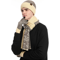 Mann mit gestricktem Winterset: Mütze, Schal, Handschuhe in Beige und Grau, stilvoll und warm.