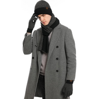 Mann in grauem Mantel mit schwarzer Mütze, Schal und Handschuhen, Wintermode Accessoires.