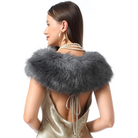 Frau mit grauem Kunstpelzkragen, goldfarbenes Kleid, Perlenkette, elegantes Abendoutfit.