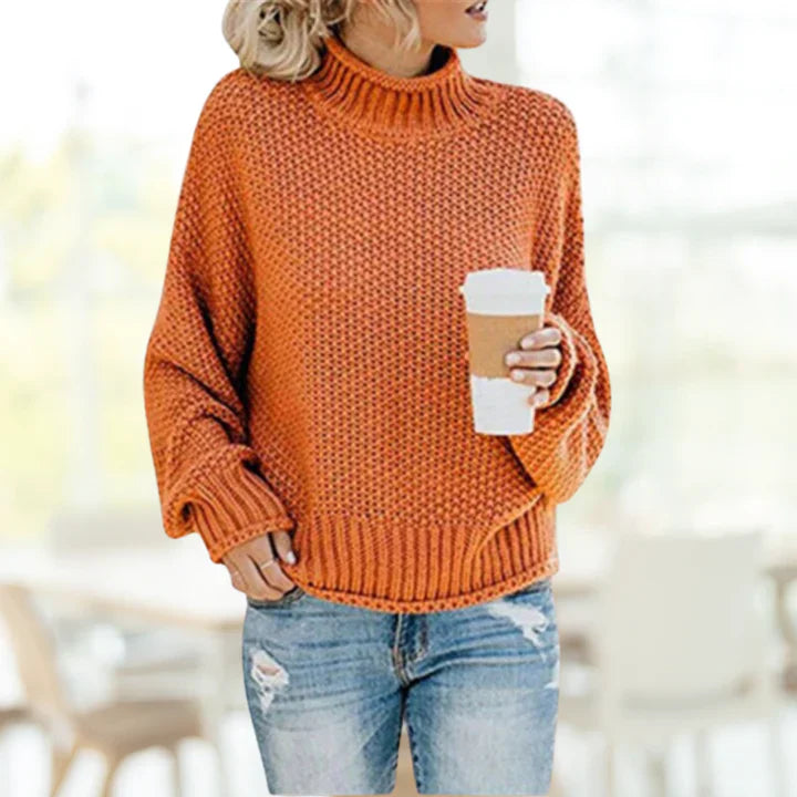 Frau in orangefarbenem Strickpullover mit Kaffeebecher, lässige Herbstmode, Jeans.