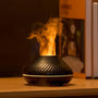 Schwarzer Aroma-Diffuser mit Flammeneffekt auf Holztisch, modernes Design, stimmungsvolle Beleuchtung.