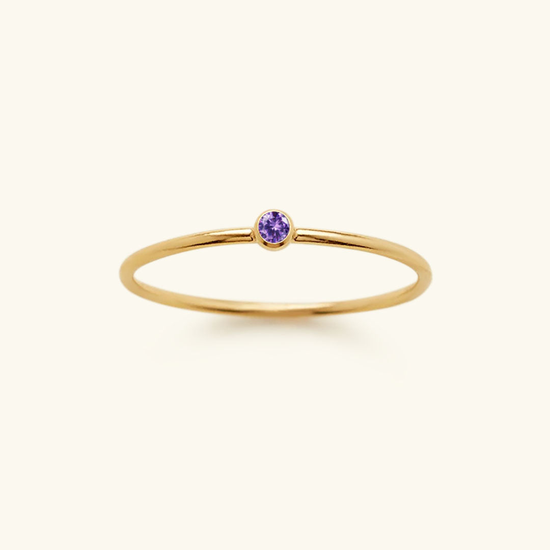 Goldener Ring mit violettem Edelstein, minimalistisches Design, eleganter Schmuck für Damen.