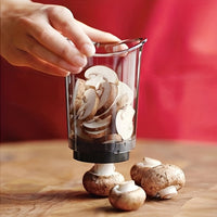 Hand hält Glas mit geschnittenen Champignons, Holzuntergrund, roter Hintergrund.