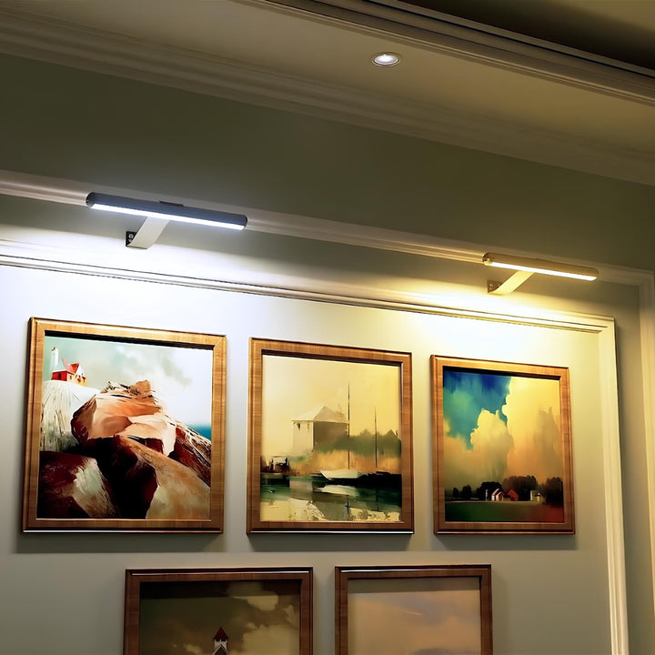 Moderne LED-Bilderleuchten beleuchten gerahmte Kunstwerke an der Wand.