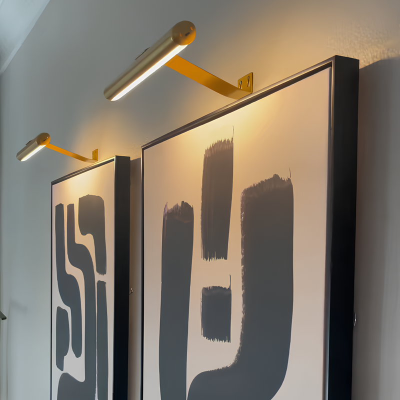 Moderne Wandkunst mit abstrakten schwarzen Formen, beleuchtet von goldenen LED-Bilderleuchten.