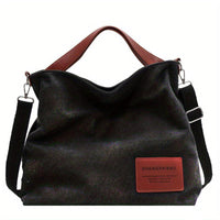 Schwarze Canvas-Schultertasche mit braunen Griffen, lässig, modisch, vielseitig.