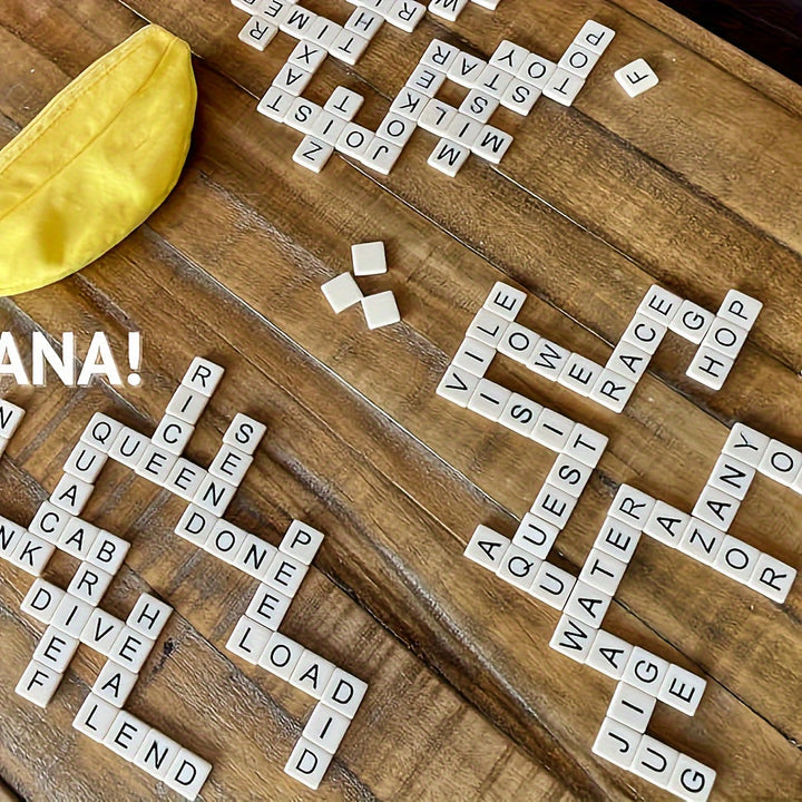 Scrabble-Spiel auf Holztisch mit gelbem Beutel, Buchstabensteine, Wörter gebildet.