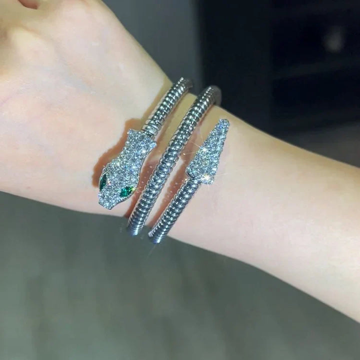 Silbernes Schlangenarmband mit Strasssteinen und grünen Augen, eleganter Schmuck für Damen.