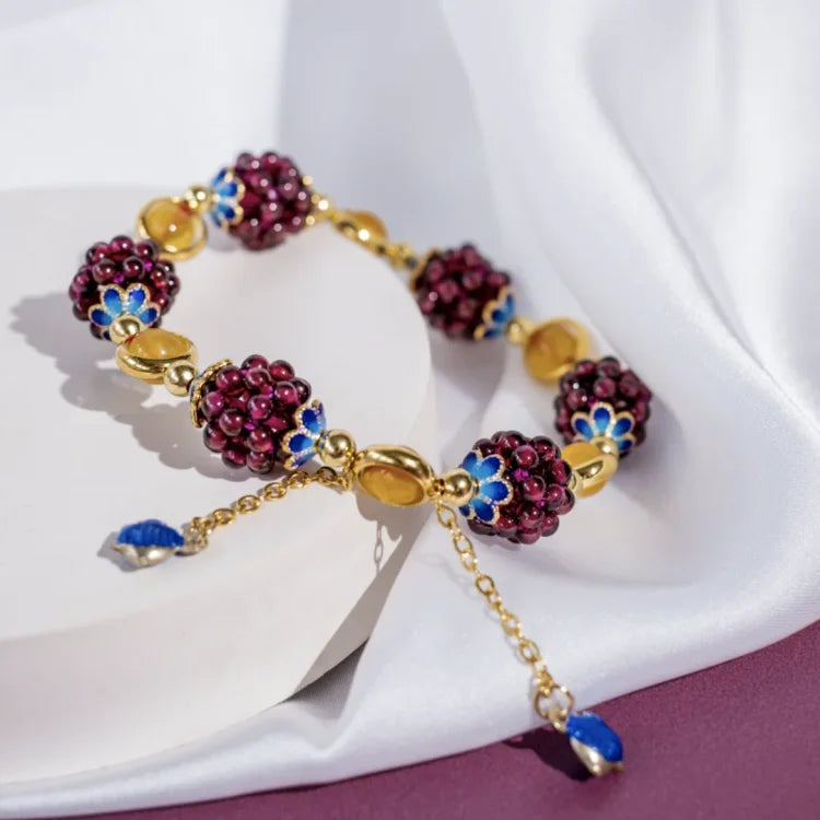 Goldenes Armband mit lila Perlen und blauen Blumen, eleganter Schmuck, Damenaccessoire.