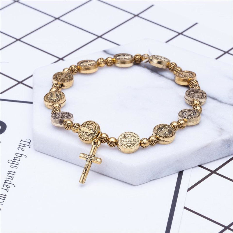 Goldenes Armband mit Kreuzanhänger, religiöses Design, runde Medaillons, modisches Accessoire.