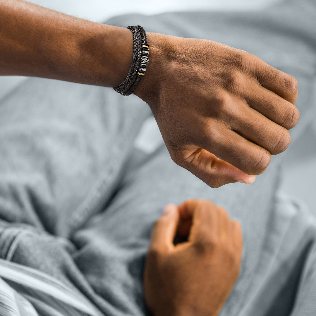 Männerarmband aus Leder, schwarz, mit Metallakzenten, modisches Accessoire, Nahaufnahme.