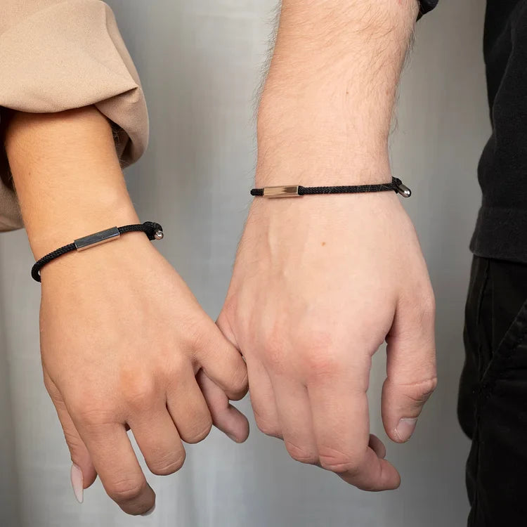 Zwei Hände mit schwarzen Armbändern aus Leder, Unisex-Schmuck, modisch, elegant.