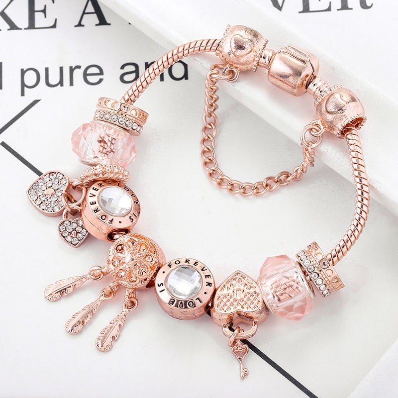 Roségoldenes Charm-Armband mit Kristallen und Herzanhängern, eleganter Schmuck für Damen.