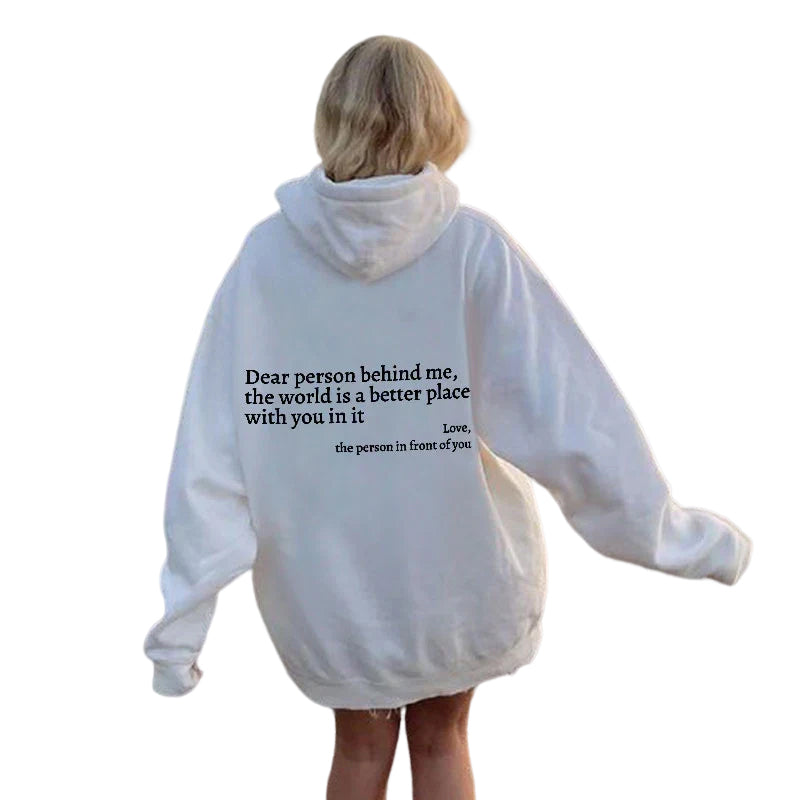 Frau in weißem Hoodie mit schwarzem Text auf Rücken, lässige Mode, Streetwear-Trend.
