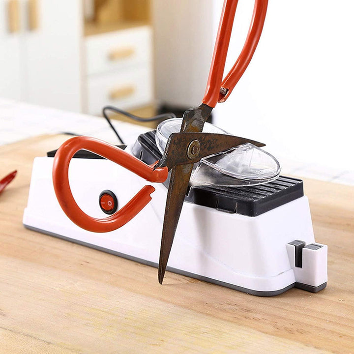 Elektrischer Messerschärfer, weiß, mit roter Schere, Küchengerät, Holzarbeitsplatte.
