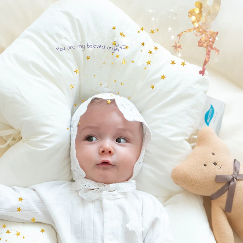 Baby auf weißem Kissen mit Teddybär, Sternen und Fee, Babybekleidung, Neugeborenenfotografie.