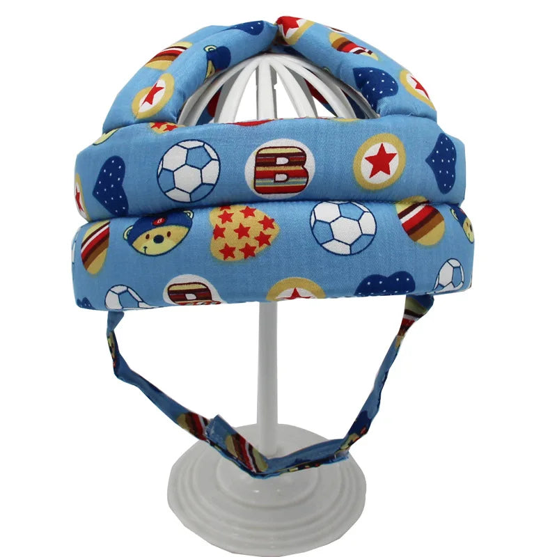 Blauer Baby-Schutzhelm mit bunten Sportmotiven, verstellbar, für Kleinkinder.
