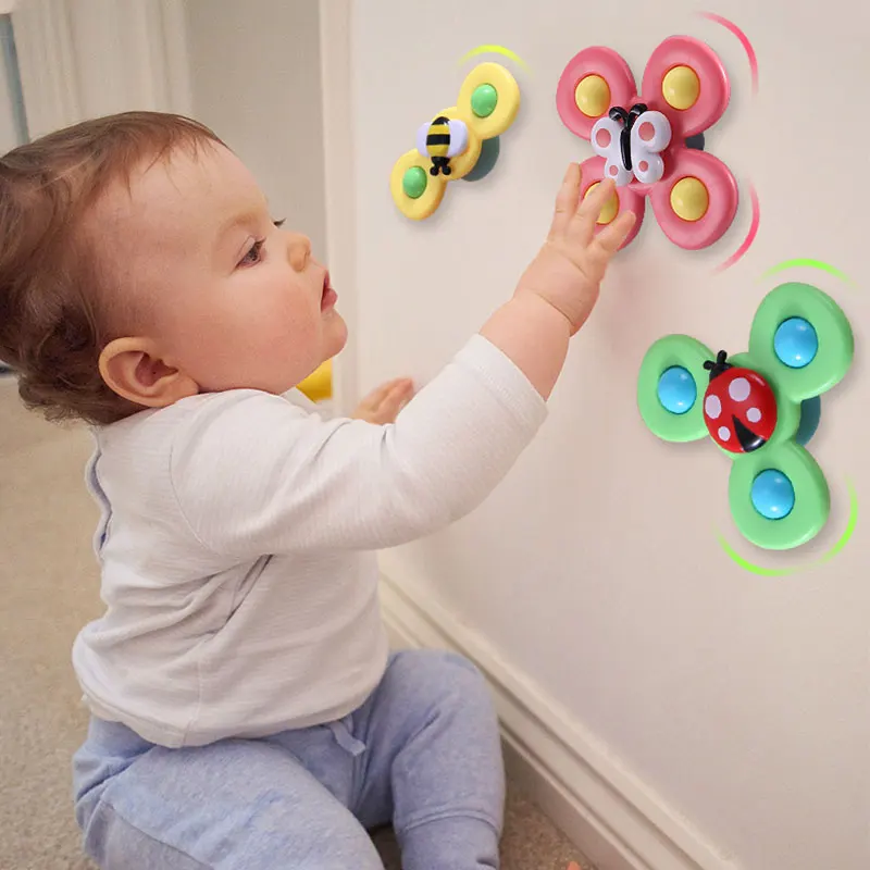 Kleinkind spielt mit bunten Schmetterling-Wandspielzeugen, pädagogisches Babyspielzeug.
