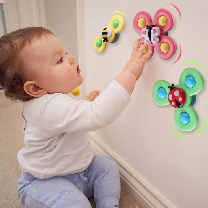 Kleinkind spielt mit bunten Schmetterling-Wandspielzeugen, pädagogisches Babyspielzeug.