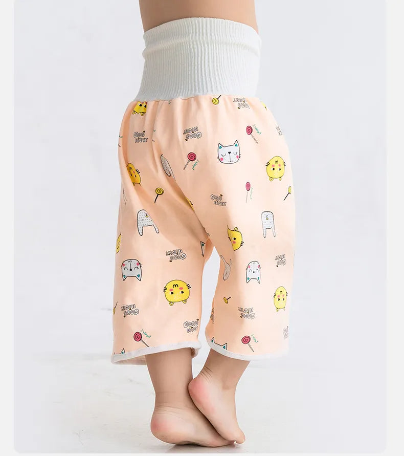 Kleinkind trägt rosa Babyhose mit Cartoon-Motiven, elastischer Bund, weicher Stoff.