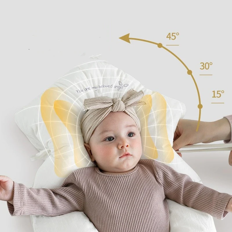 Baby auf ergonomischem Kissen, beige Stirnband, brauner Strampler, Kopfstütze, Neigungswinkel.