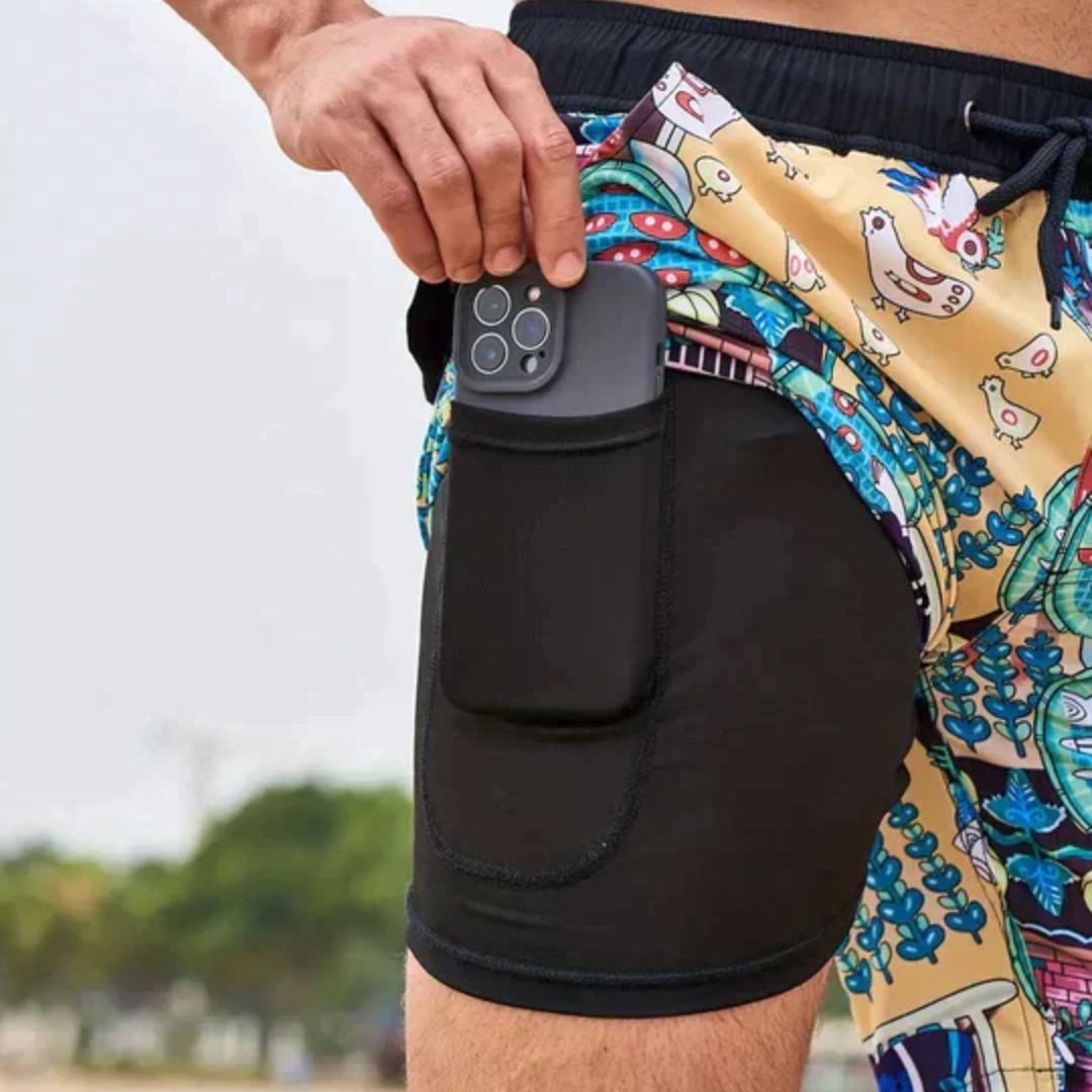 Mann mit Smartphone in bunter Badehose, Strandmode, Sommer, Handyhalter, Freizeitkleidung.
