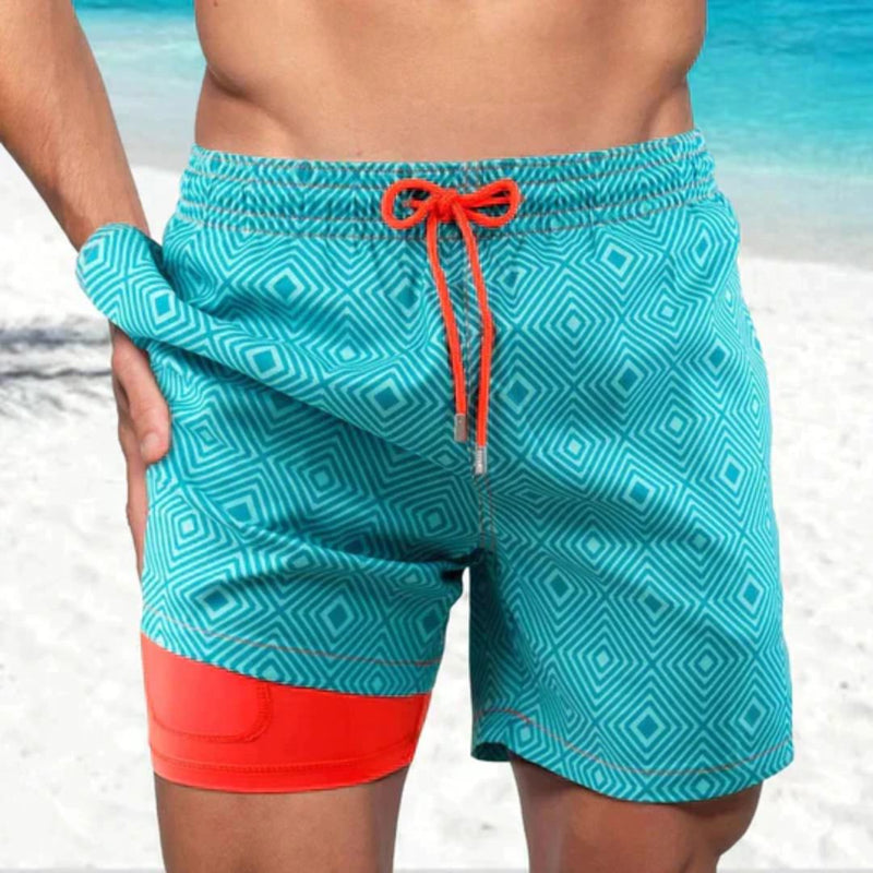 Männer-Badeshorts türkis mit geometrischem Muster und rotem Akzent, Strandmode.