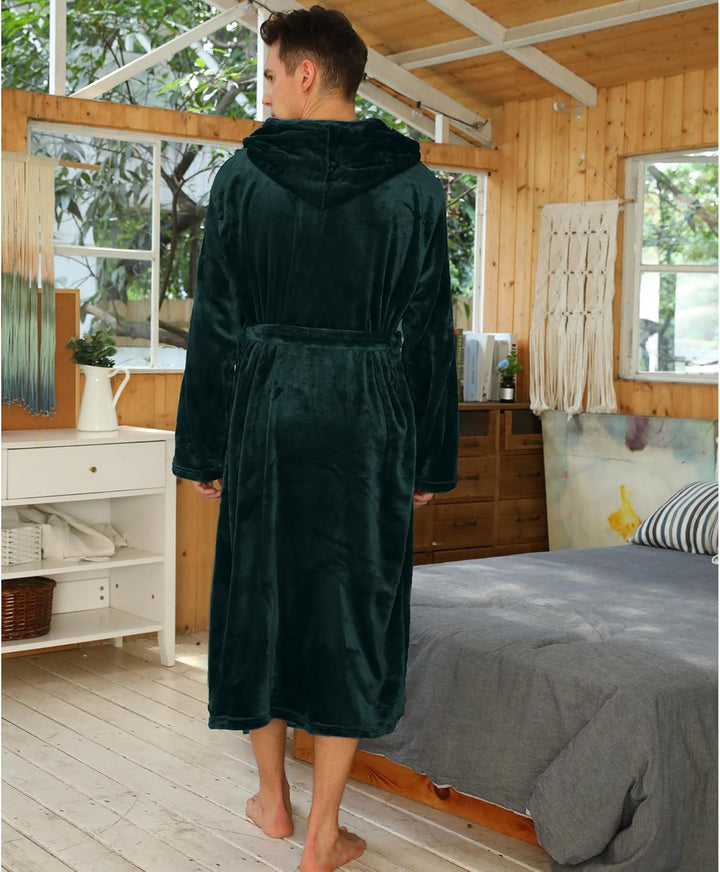 Mann im dunkelgrünen Fleece-Bademantel mit Kapuze im Schlafzimmer, gemütliche Morgenroutine.