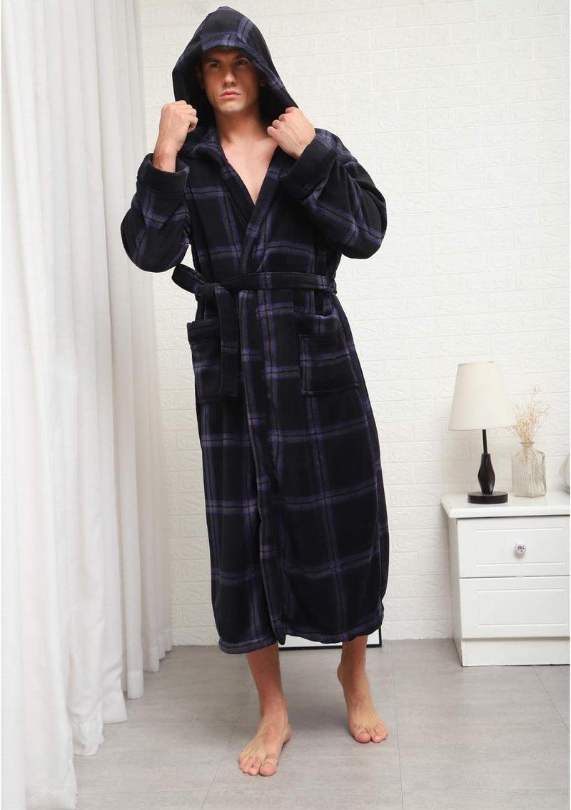 Mann im karierten, schwarzen Bademantel mit Kapuze, stehend im Schlafzimmer.