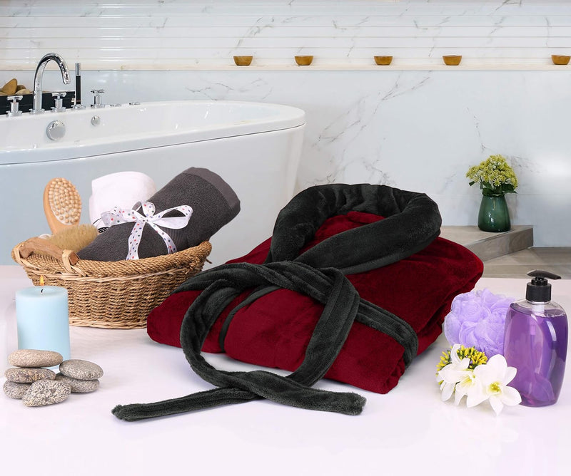 Roter Bademantel aus Fleece im Badezimmer, neben Badewanne, Kerzen und Handtüchern.