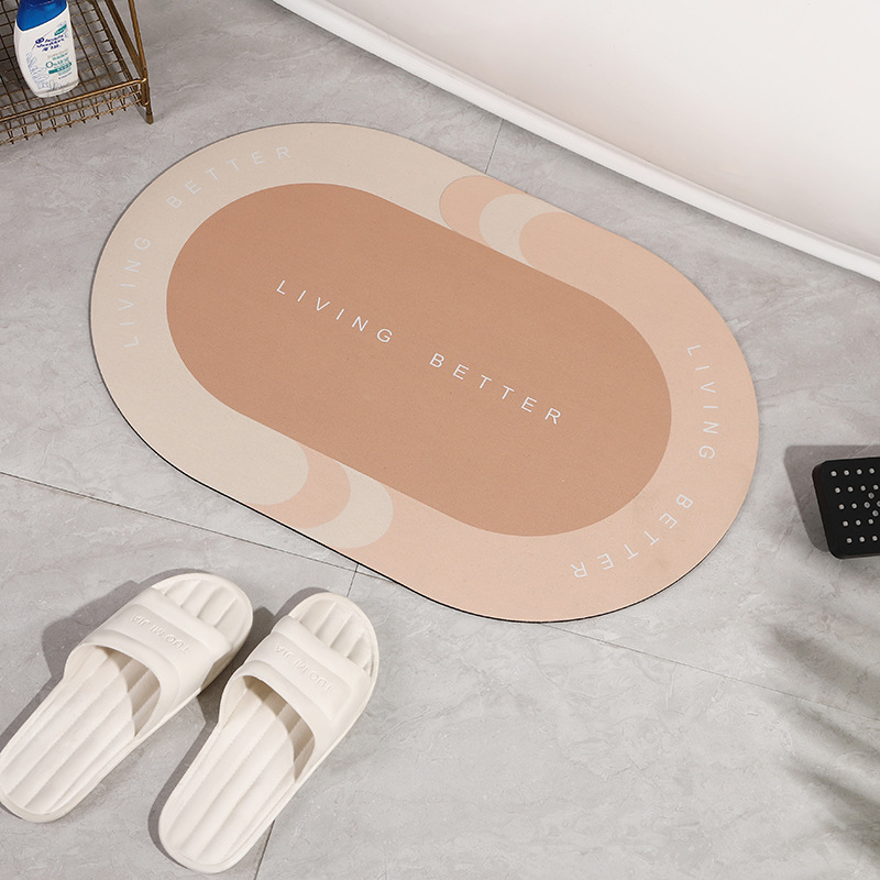 Beiger Badematte mit Aufschrift "Living Better", oval, rutschfest, auf grauem Fliesenboden.