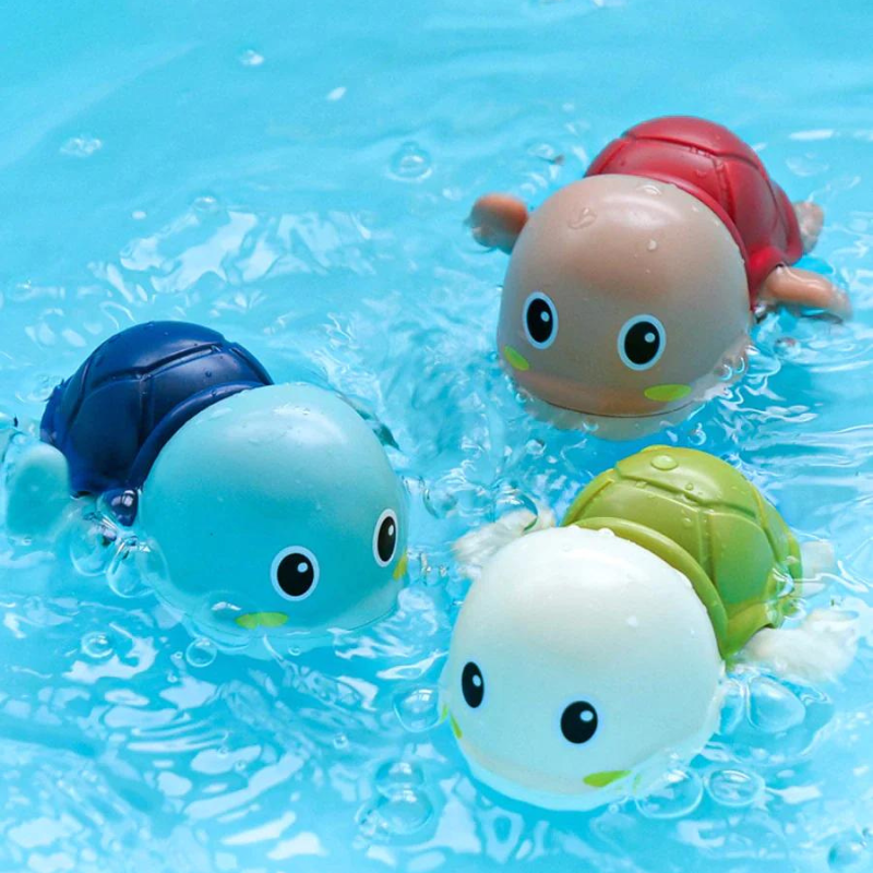 Vier bunte schwimmende Schildkröten-Badespielzeuge im Wasser, blau, rot, grün, weiß.