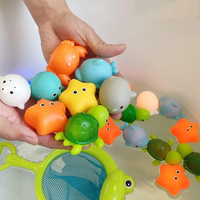 Bunte Badespielzeuge für Kinder, Meerestiere, Kunststoff, schwimmend, im Wasser gehalten.