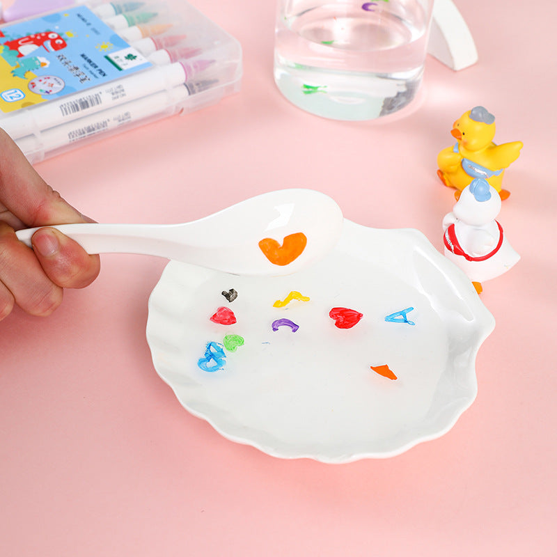 Weiße Keramikschale mit bunten Wasserfarben, Herzform, kreative Kunst, rosa Hintergrund.